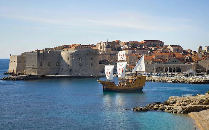 Sailing ship near Dubrovnik's historic city walls on Elaphite Islands cruise.
