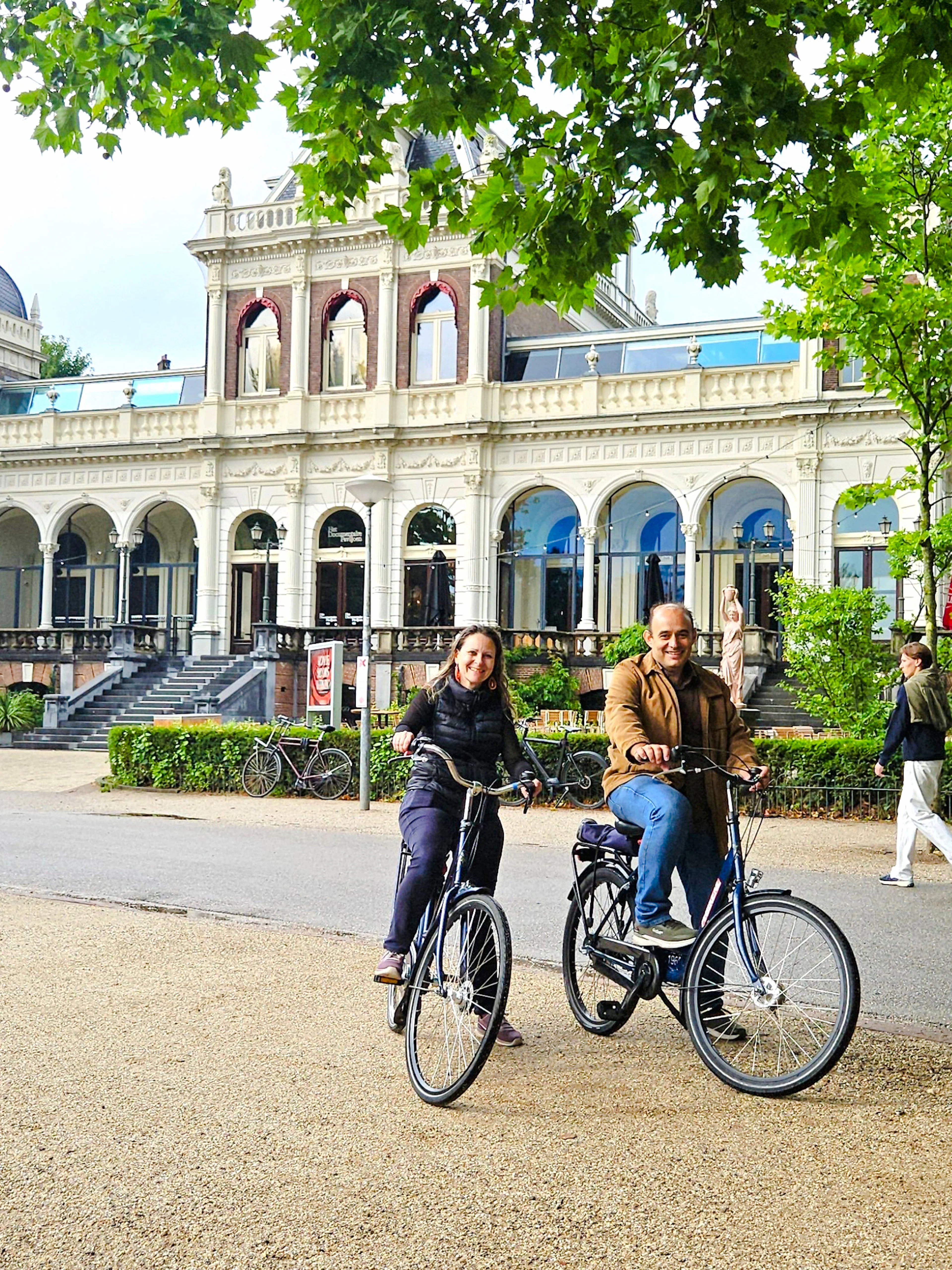 Cyclists in front of Vondelpark Pavilion during Amsterdam City Highlights Bike Tour.