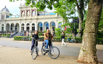 Cyclists in front of Vondelpark Pavilion during Amsterdam City Highlights Bike Tour.