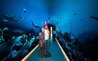 Family exploring underwater-themed tunnel at The View at the Palm, Dubai.