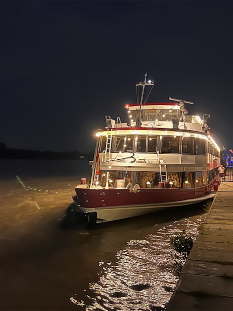 Dinner cruise boat docked on the Danube River in Budapest at night.