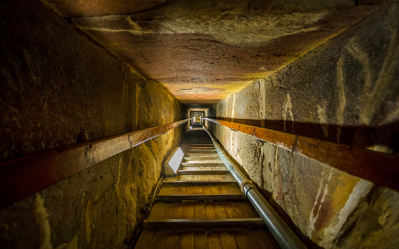 Stairway leading to the tomb inside a pyramid, showcasing narrow passage and stone walls.