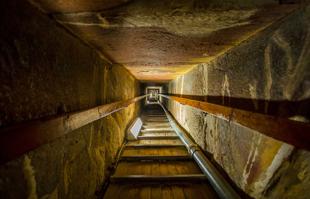 Stairway leading to the tomb inside a pyramid, showcasing narrow passage and stone walls.