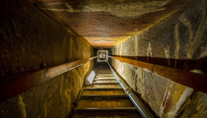 Stairway leading to the tomb inside a pyramid, showcasing narrow passage and stone walls.