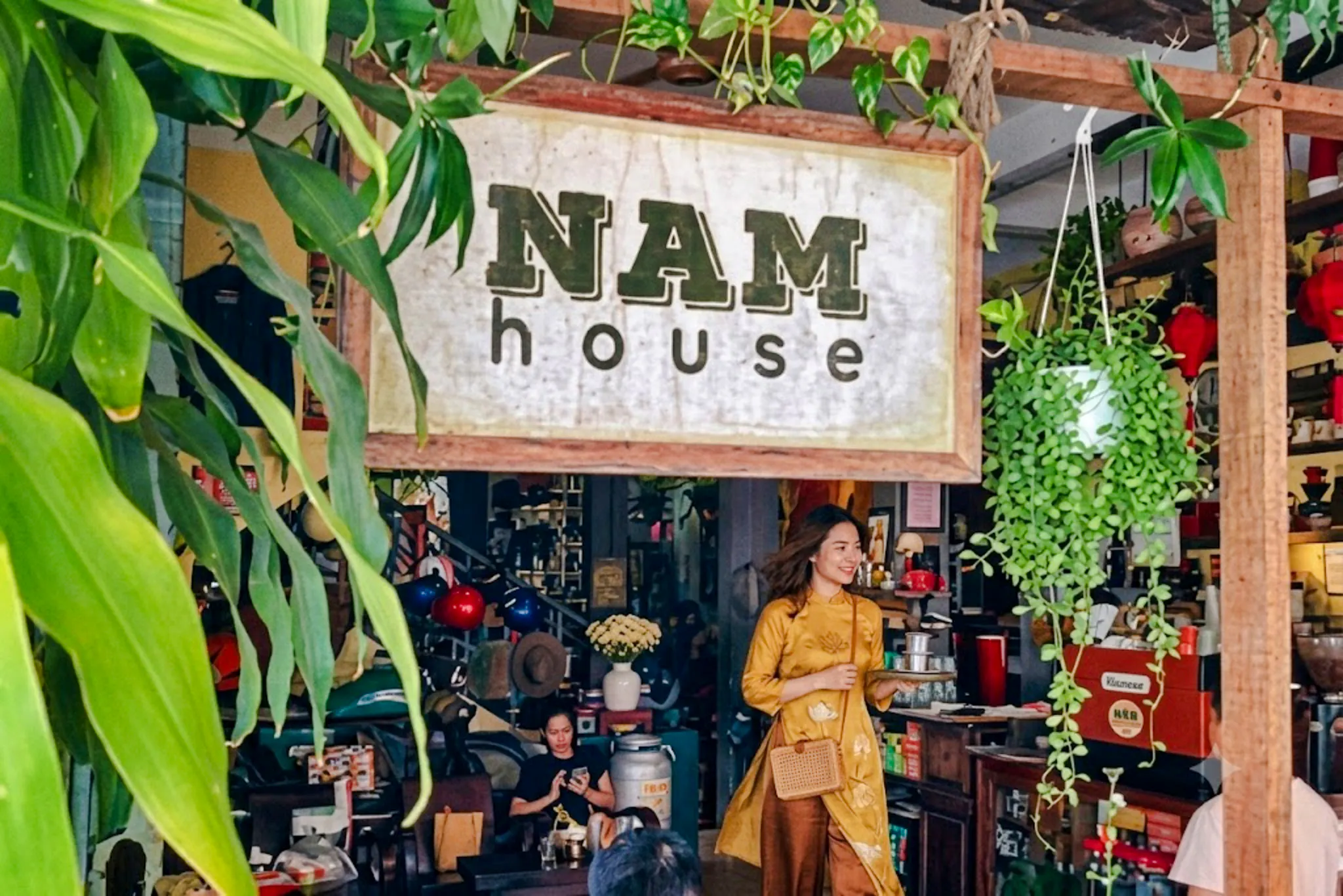 Hidden cafe interior with a woman in traditional attire, Da Nang.