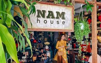Hidden cafe interior with a woman in traditional attire, Da Nang.