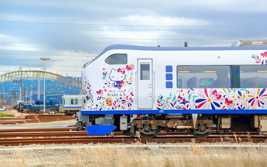 JR Haruka Airport Express train with Hello Kitty design on tracks.