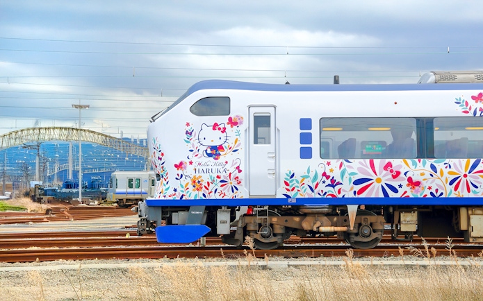 JR Haruka Airport Express train with Hello Kitty design on tracks.