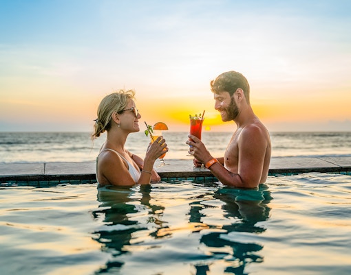 People dining and enjoying drinks at the poolside paradise in Atlas Beach Club, Bali.