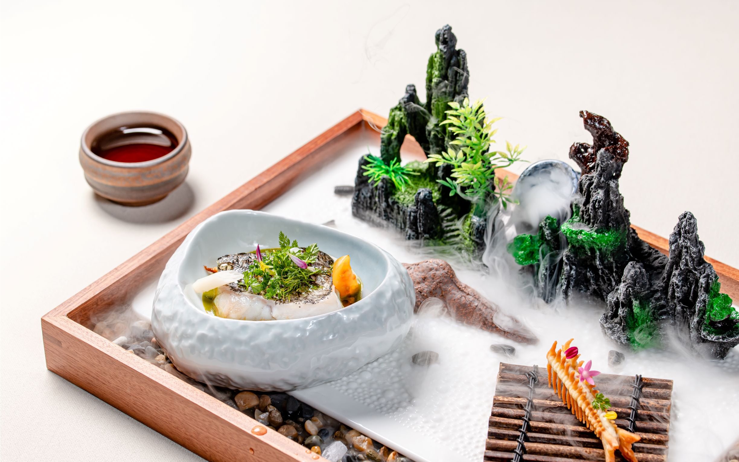 Curated dish on themed tray with miniature landscape at Taste of China, Shanghai.
