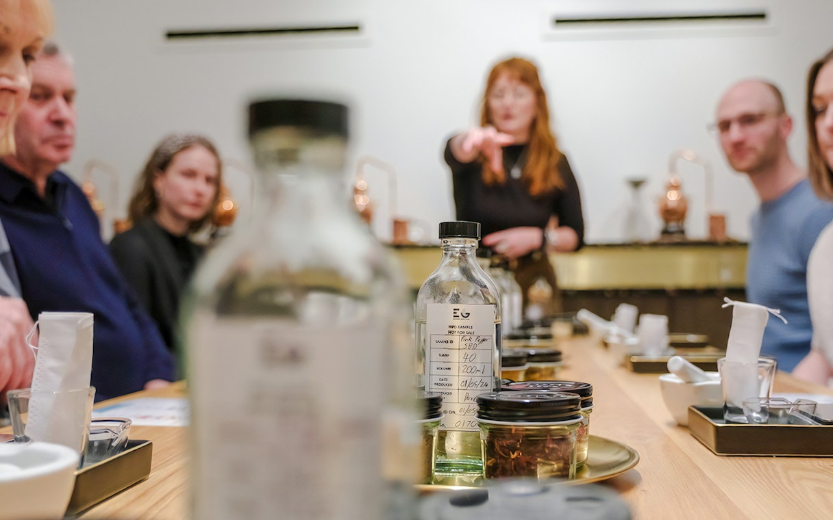 Participants at a gin making class in Edinburgh, focusing on bottles and ingredients on the table.