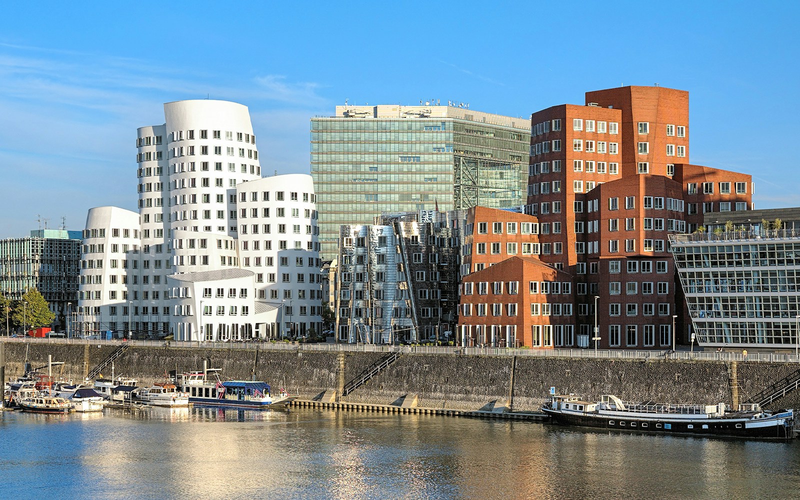 Neuer Zollhof buildings along the Rhine River in Düsseldorf, featuring unique architecture.