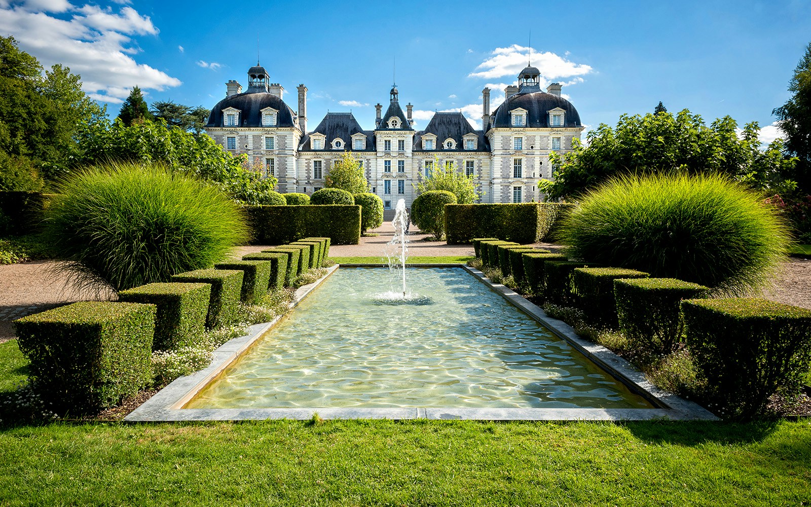 Château de Cheverny facade with manicured gardens in Loire Valley, France.