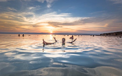Floating man in Dead Sea at sunset, Jordan.