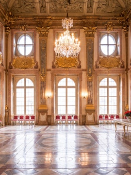 Mirabell Palace interior with ornate ceiling, chandelier, and large windows in Salzburg, Austria.