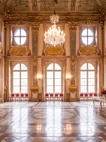 Mirabell Palace interior with ornate ceiling, chandelier, and large windows in Salzburg, Austria.