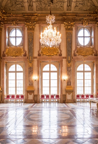 Mirabell Palace interior with ornate ceiling, chandelier, and large windows in Salzburg, Austria.