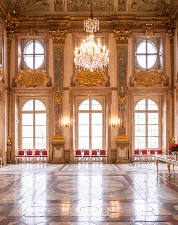 Mirabell Palace interior with ornate ceiling, chandelier, and large windows in Salzburg, Austria.