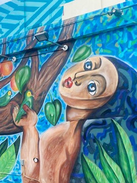Mural of a figure with birds and leaves at Wynwood Walls, Miami, Florida.
