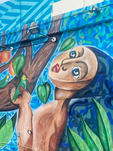 Mural of a figure with birds and leaves at Wynwood Walls, Miami, Florida.