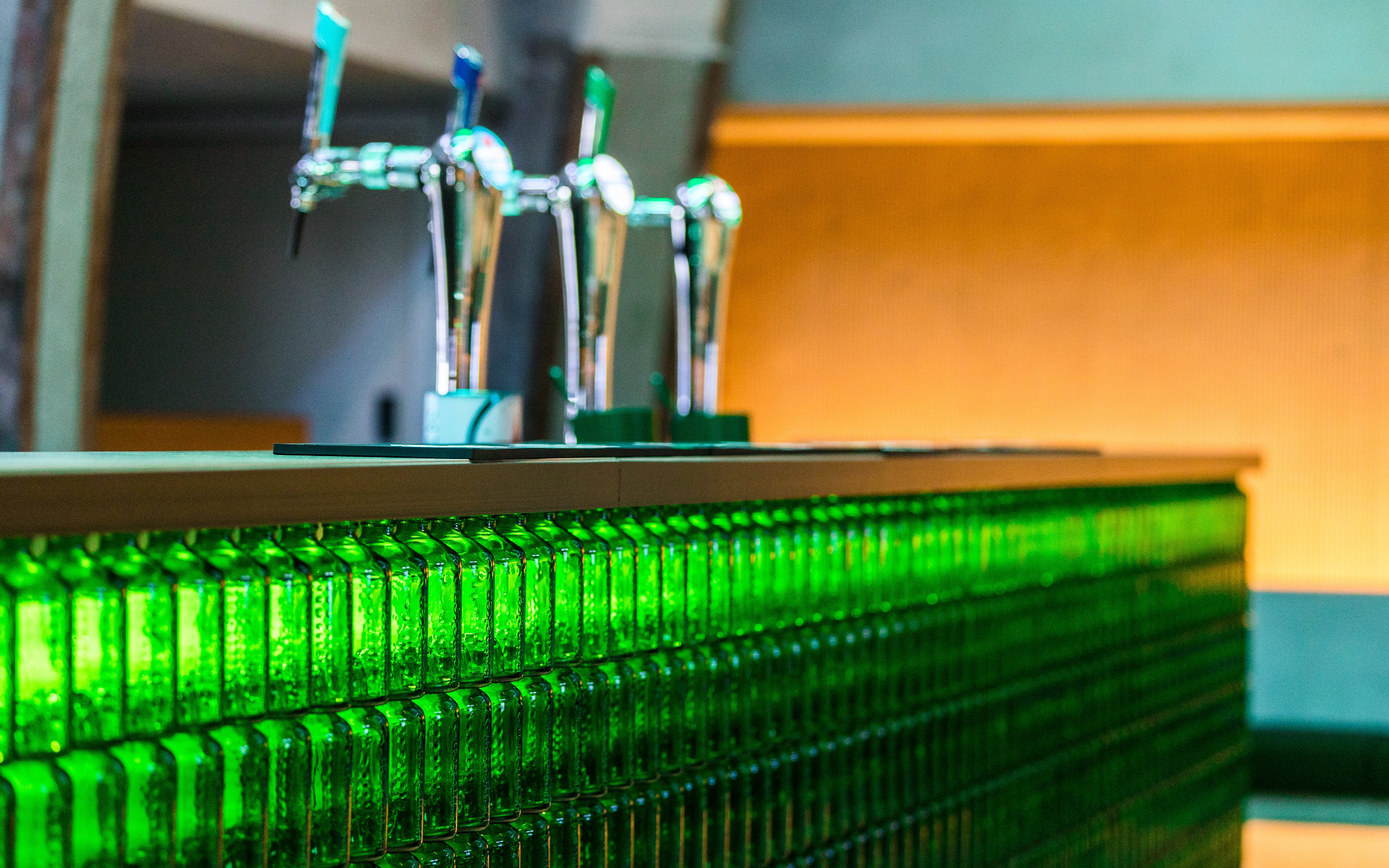Heineken rooftop bar with beer taps and green bottle decor.
