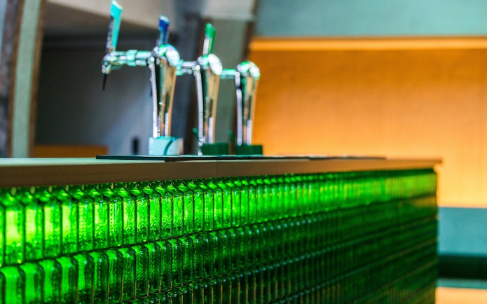 Heineken rooftop bar with beer taps and green bottle decor.