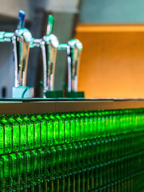 Heineken rooftop bar with beer taps and green bottle decor.