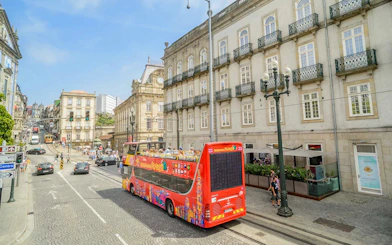 Hop-on hop-off bus touring historic buildings in Porto, Portugal.