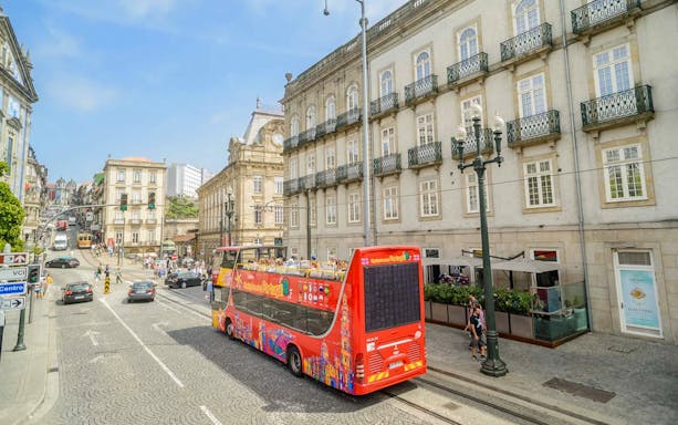 Hop-on hop-off bus touring historic buildings in Porto, Portugal.