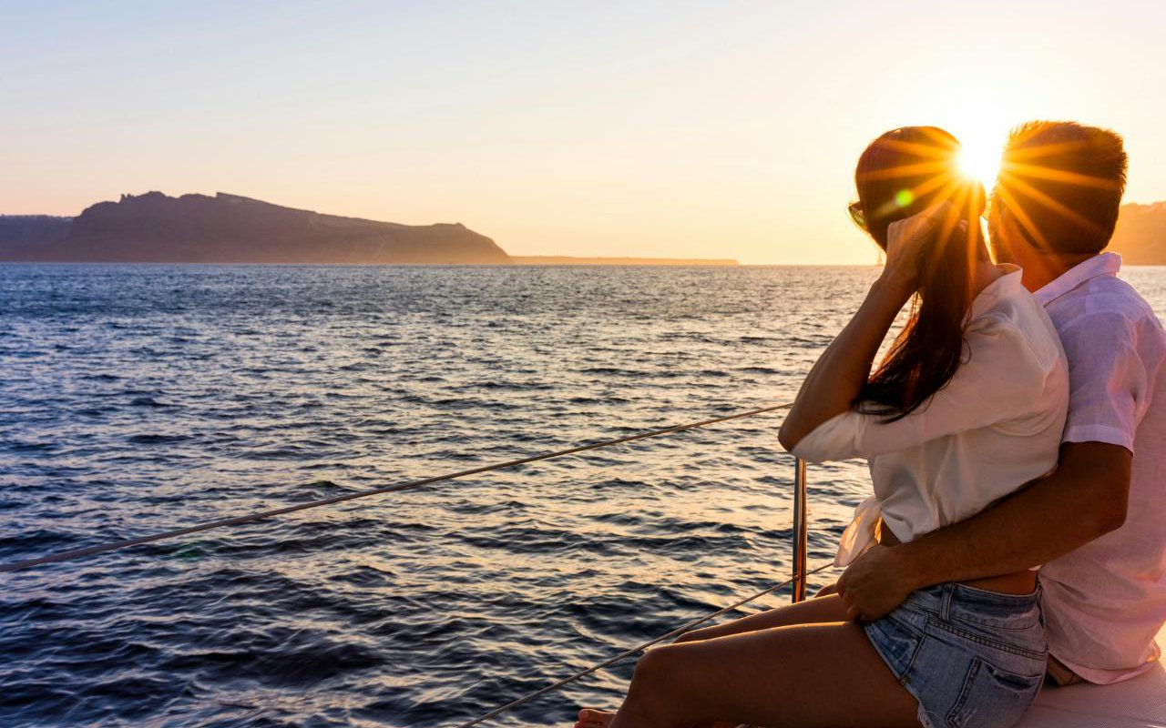 Tourists enjoying a sunset cruise on a classic boat in Ibiza.