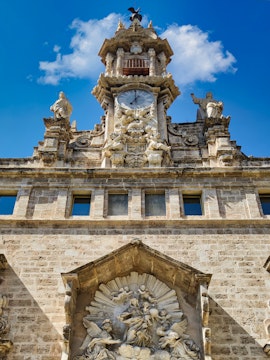 Santos Juanes Church facade with clock and sculptures, Valencia, Spain.