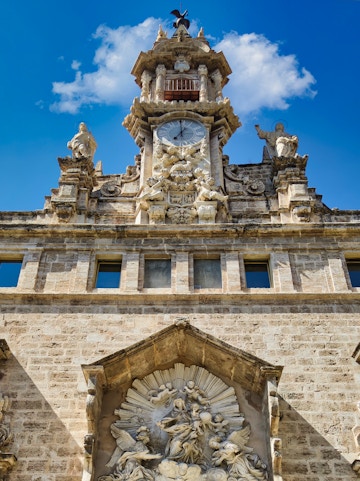 Santos Juanes Church facade with clock and sculptures, Valencia, Spain.