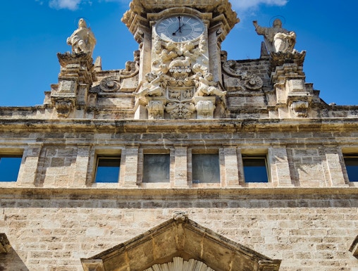 Santos Juanes Church facade with clock and sculptures, Valencia, Spain.