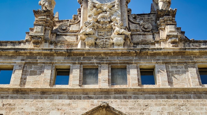 Santos Juanes Church facade with clock and sculptures, Valencia, Spain.