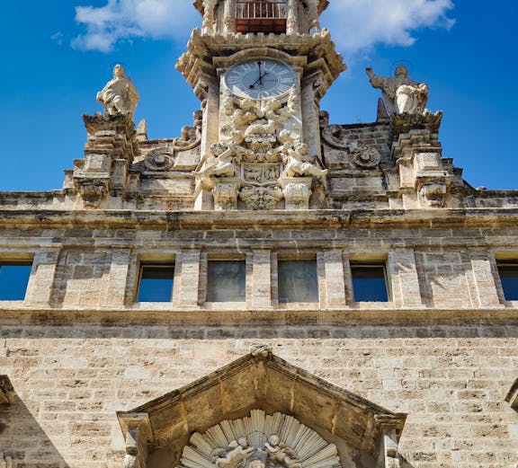 Santos Juanes Church facade with clock and sculptures, Valencia, Spain.
