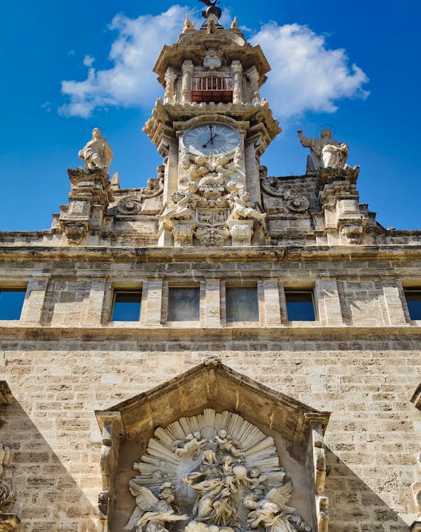 Santos Juanes Church facade with clock and sculptures, Valencia, Spain.