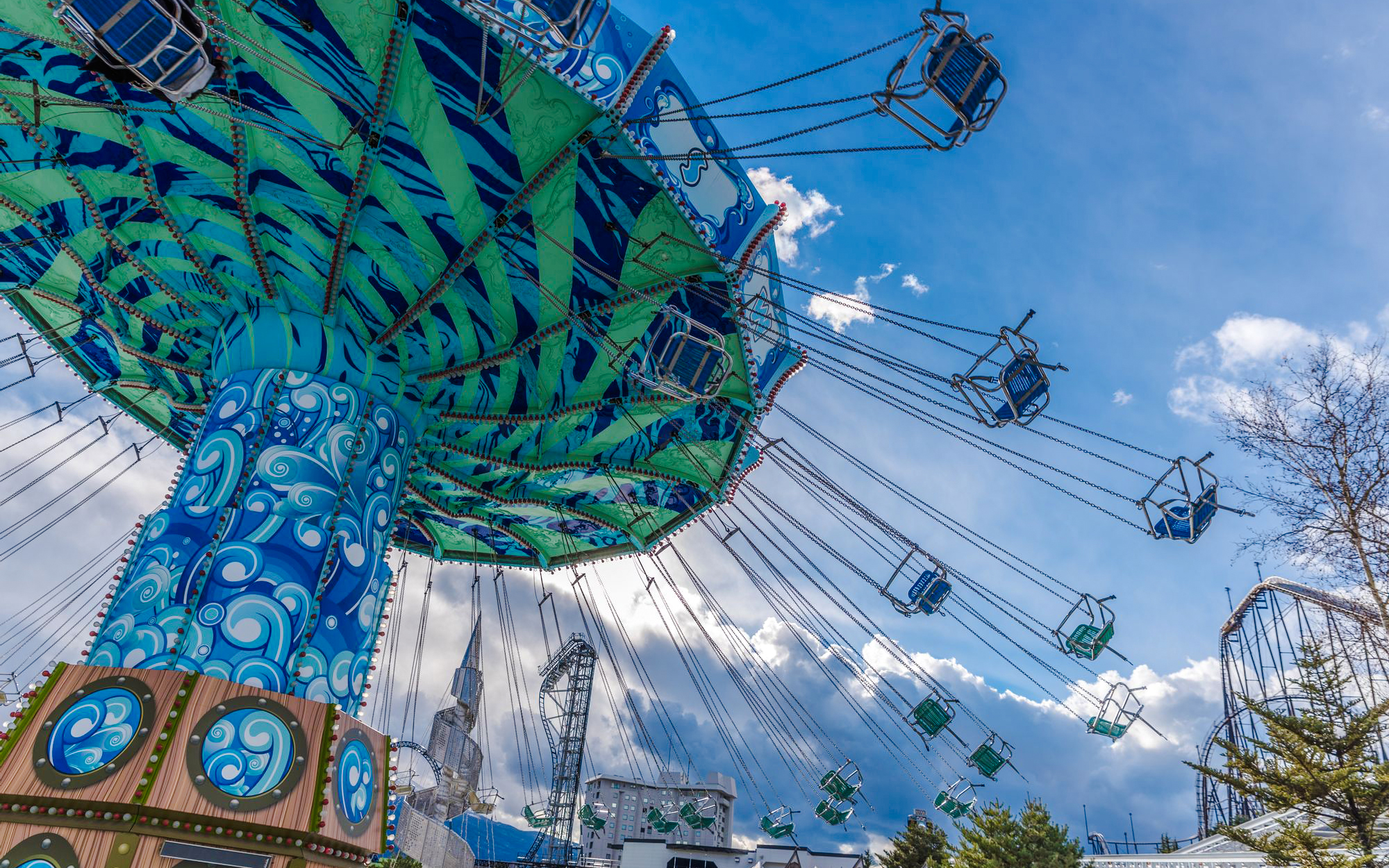 Giant Swing ride at Fuji-Q Highland amusement park, Japan, with colorful design and empty seats.