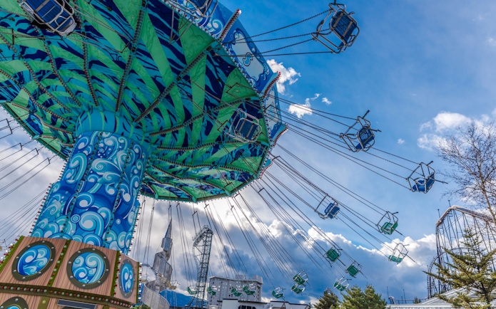 Giant Swing ride at Fuji-Q Highland amusement park, Japan, with colorful design and empty seats.