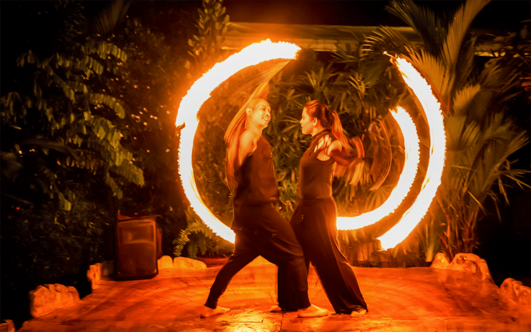 Fire dancers performing at night during a Hybrid Twilight Performance.