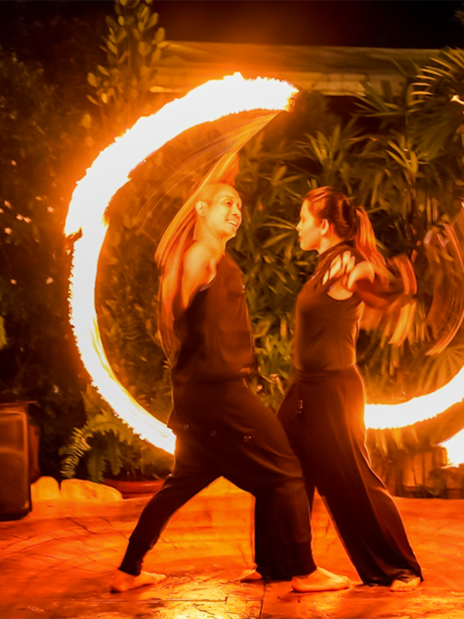 Fire dancers performing at night during a Hybrid Twilight Performance.