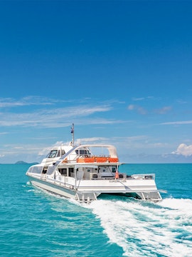 Catamaran sailing on turquoise waters near Whitsunday Islands, Australia.