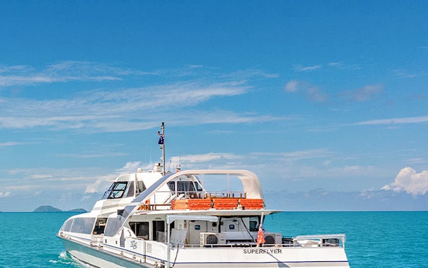 Catamaran sailing on turquoise waters near Whitsunday Islands, Australia.