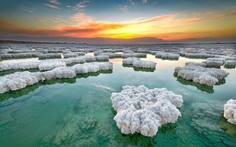 Salt formations in the Dead Sea at sunset during a tour from Amman to Petra, Wadi Rum, and Dead Sea.