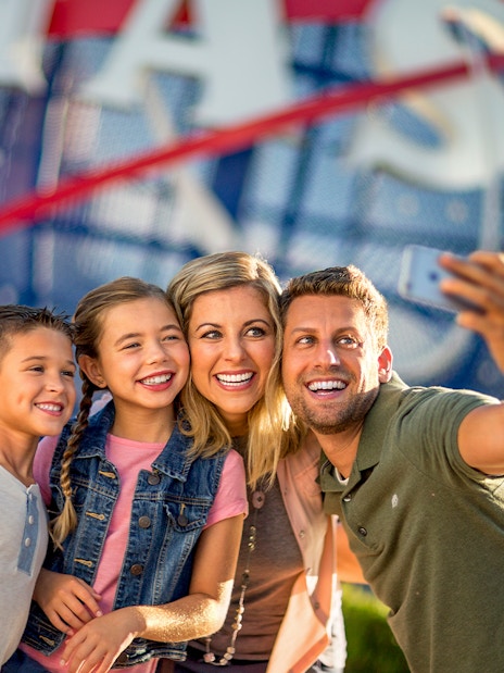 Visitors taking a selfie at Kennedy Space Center with NASA globe in background.