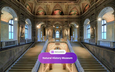 Staircase inside Natural History Museum Vienna with ornate ceilings and statues.