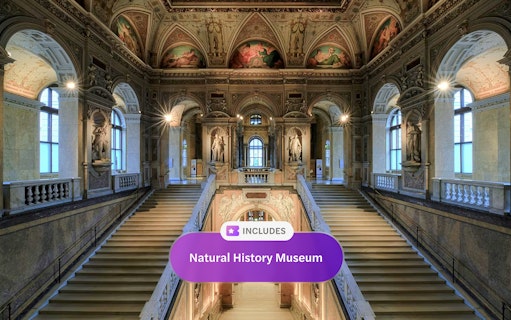 Staircase inside Natural History Museum Vienna with ornate ceilings and statues.
