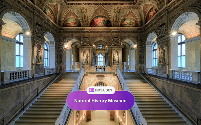 Staircase inside Natural History Museum Vienna with ornate ceilings and statues.