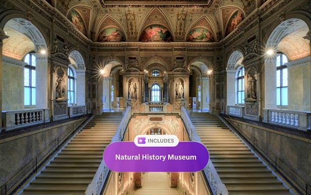 Staircase inside Natural History Museum Vienna with ornate ceilings and statues.