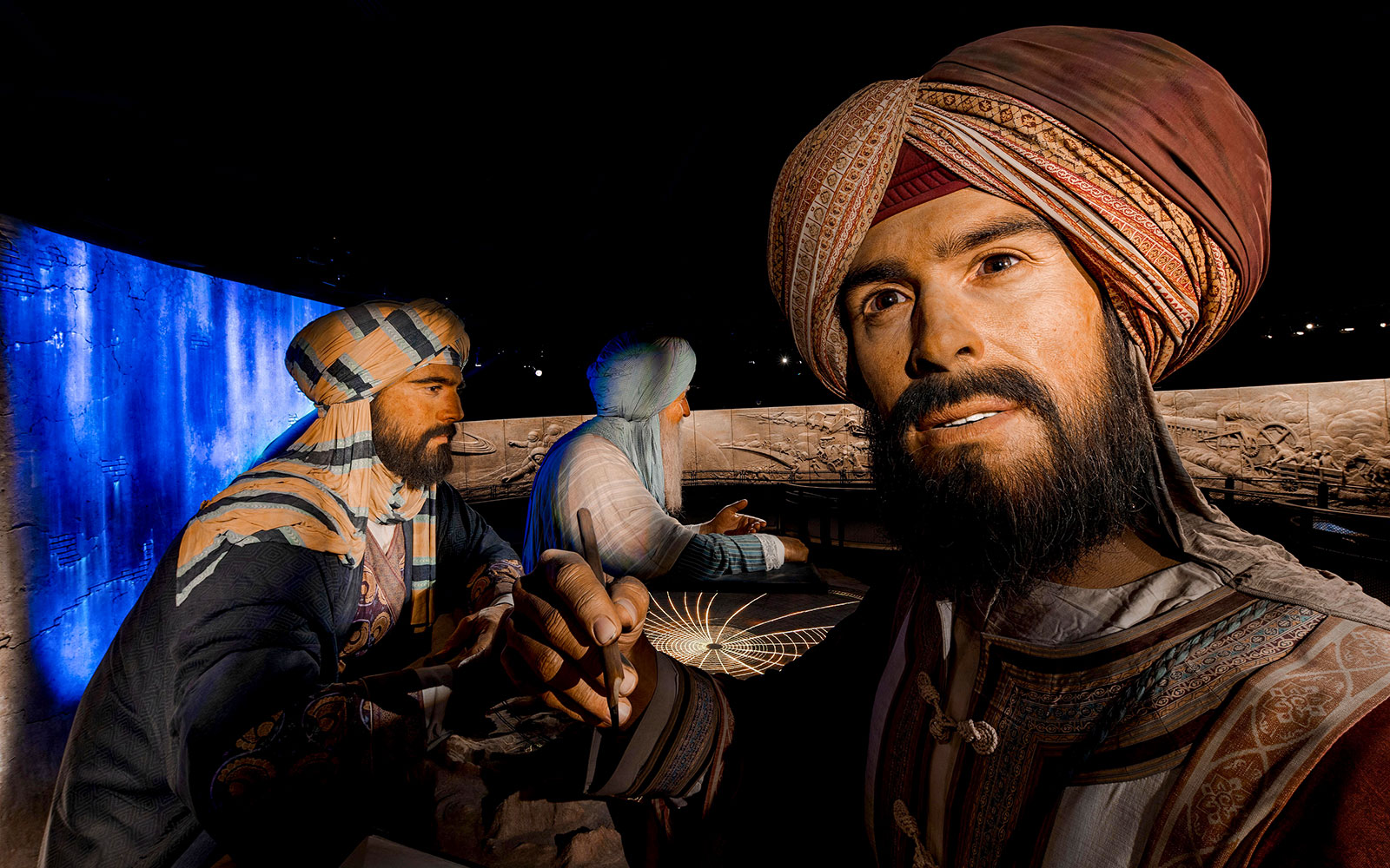 Three historical figures in traditional attire at Expo City Dubai exhibit.