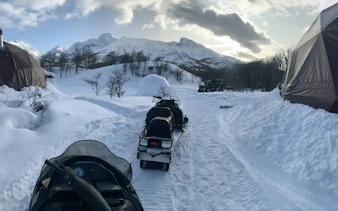 Snowmobiles on a snowy trail with mountains in Ushuaia.